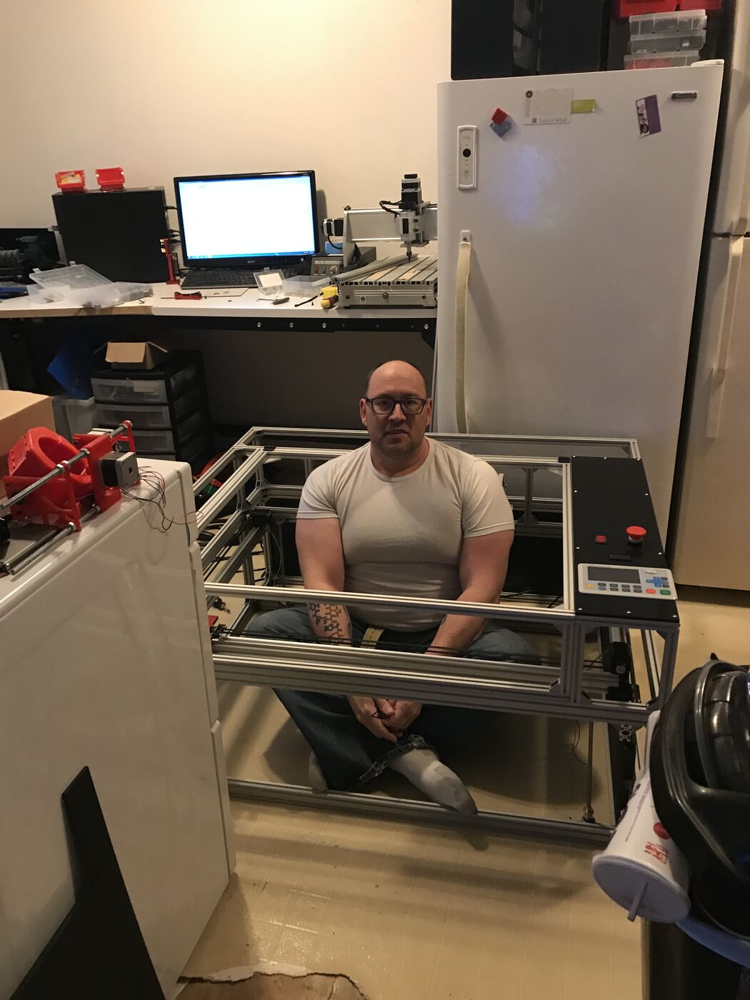 David Bleeke sitting inside the laser cutter frame, showing its size