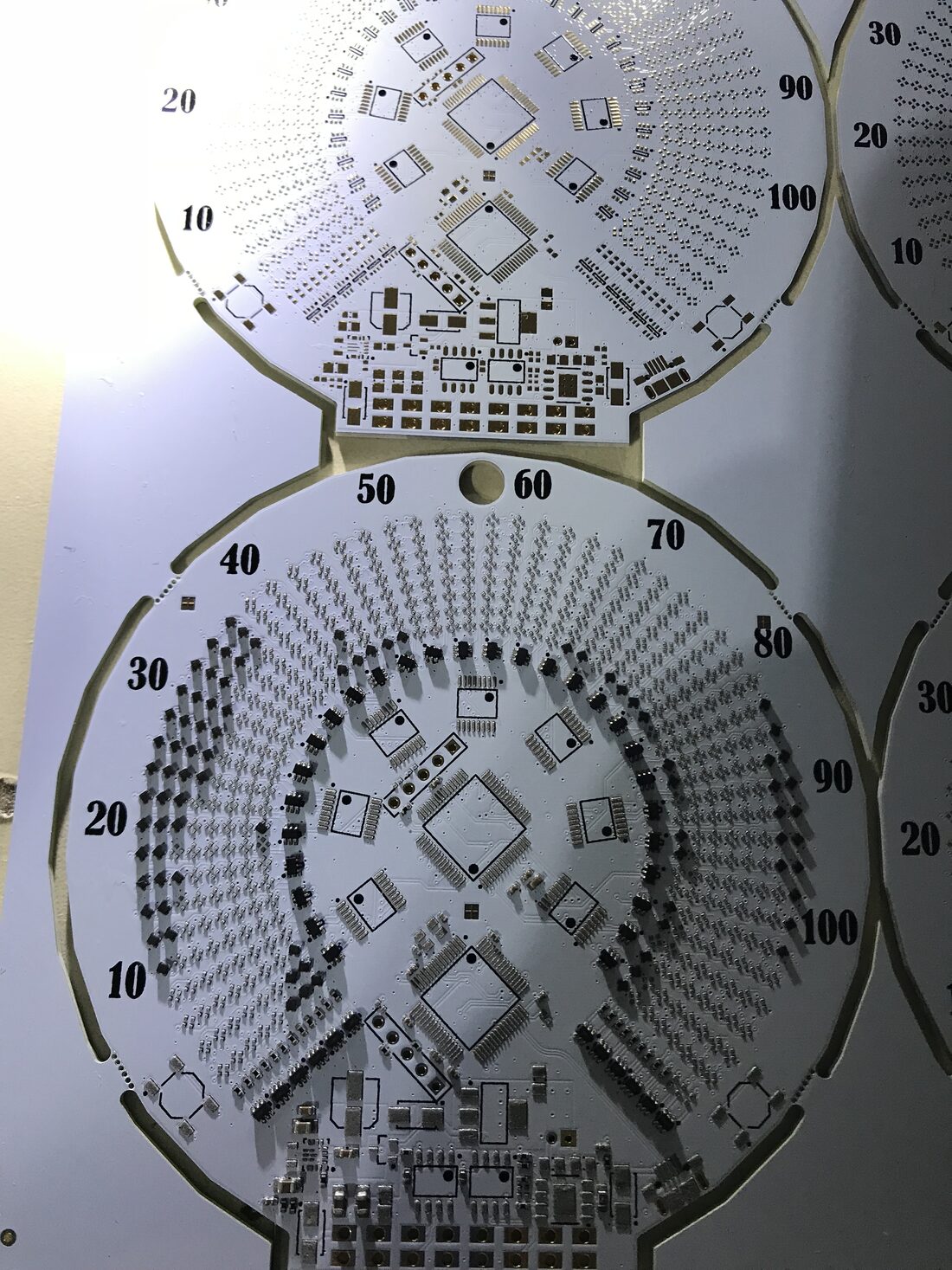 Two boards on a panel partly populated with parts, showing assembly in progress